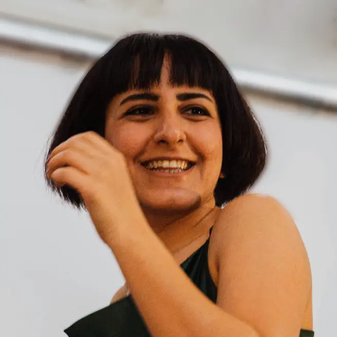 Ragazza mora con sorriso a tre quarti